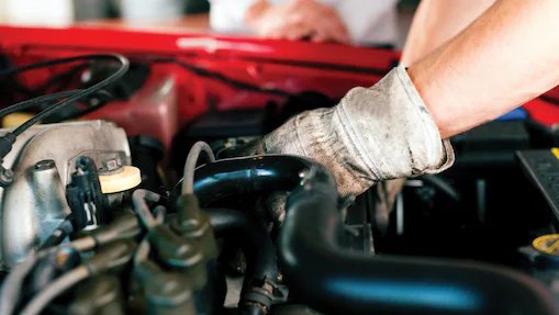 Mechanic wearing gloves fixing an engine