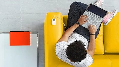 A man sitting on a sofa with his laptop